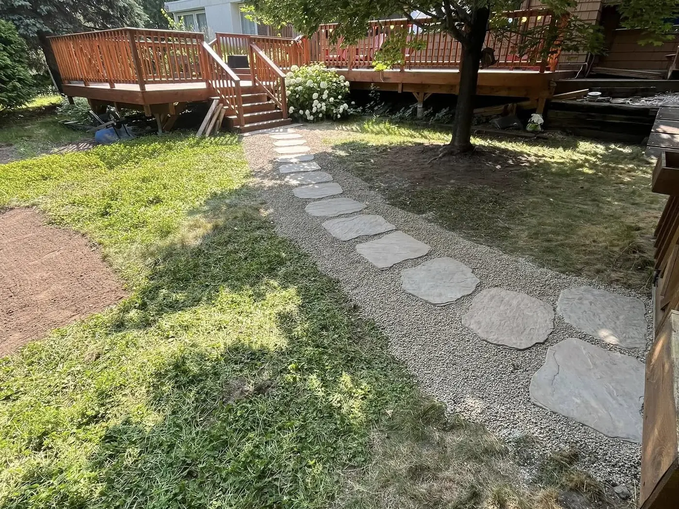 Stone walkway installed through a shaded yard