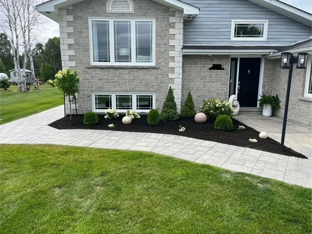 Front garden along a stone-faced home and curved walkway — after, pair 16 of 36