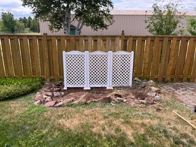 Backyard planting bed with a white lattice screen — before, pair 18 of 36