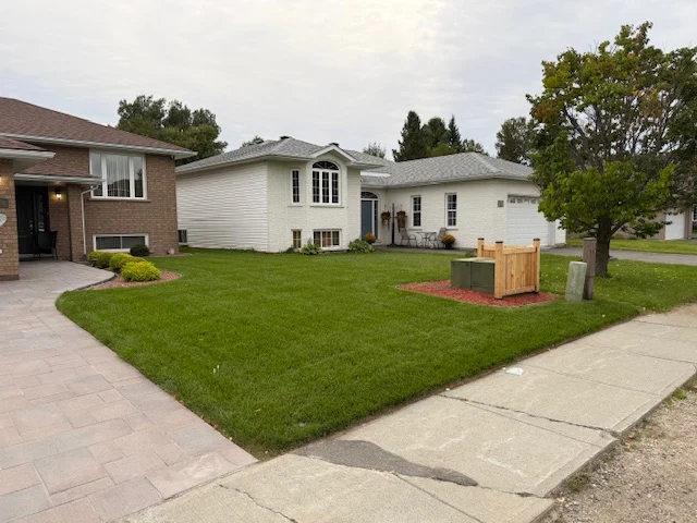 Front lawn beside the entrance and garden of a brick home — after, pair 36 of 36
