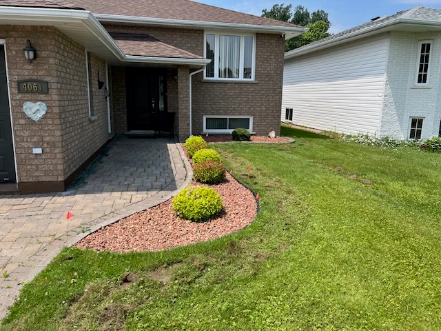 Front lawn beside the entrance and garden of a brick home — before, pair 36 of 36