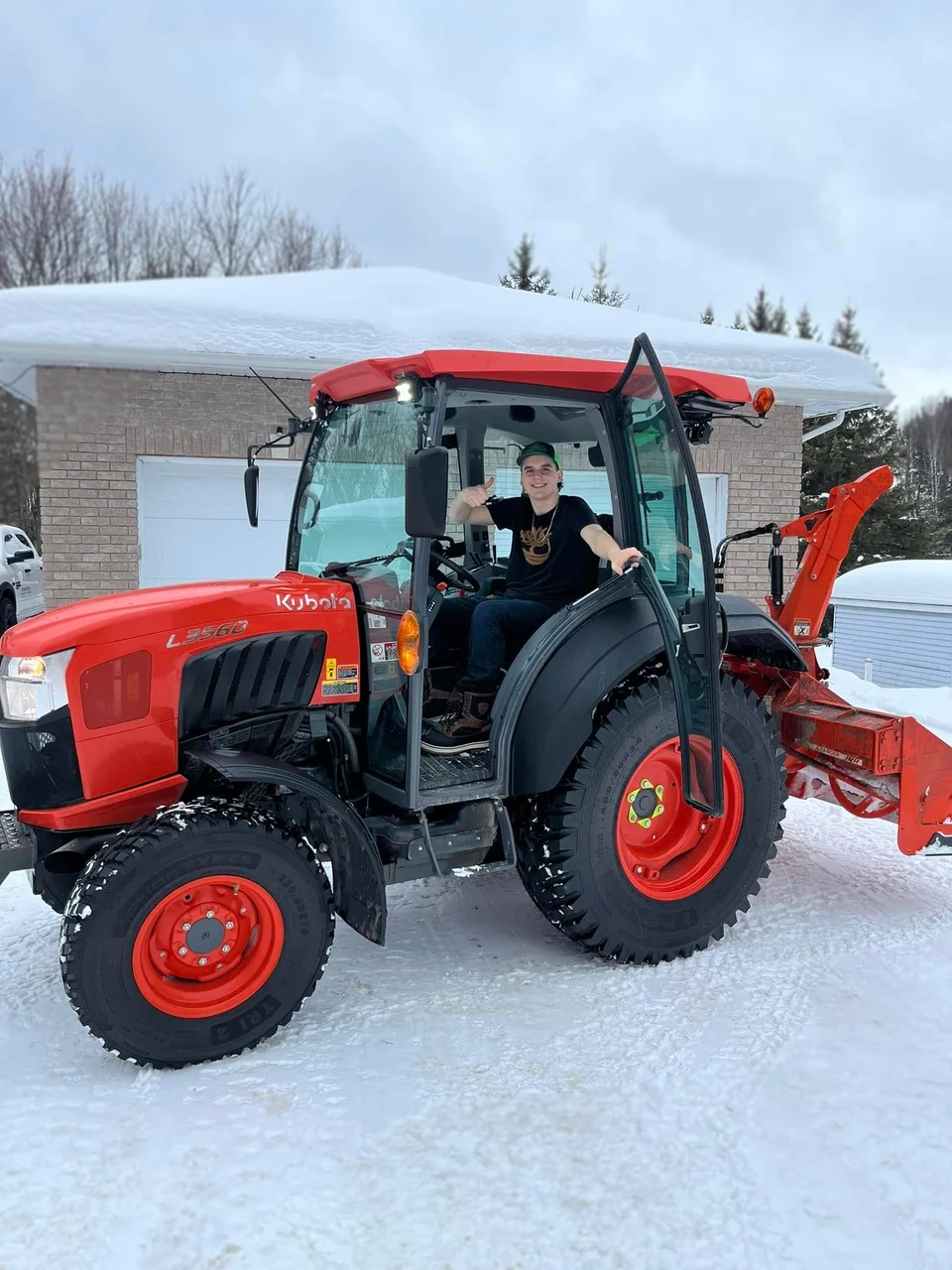 Picture Perfect orange tractor and snow equipment outside a home in daylight