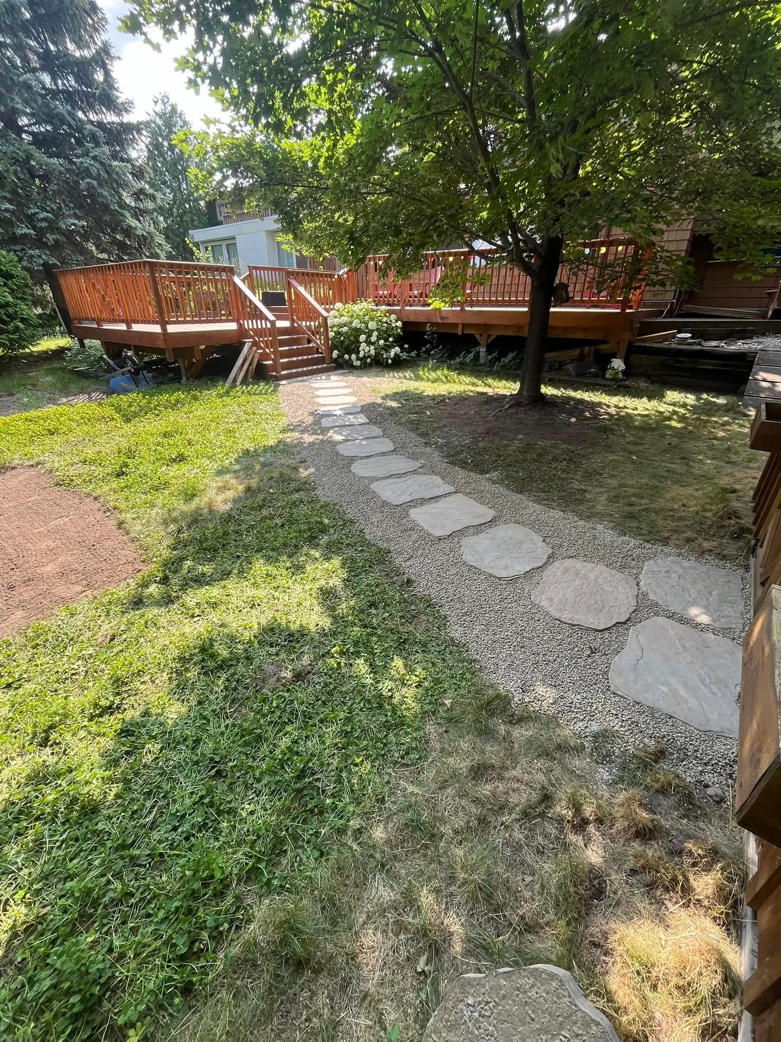 Natural stone walkway curving through a landscaped backyard